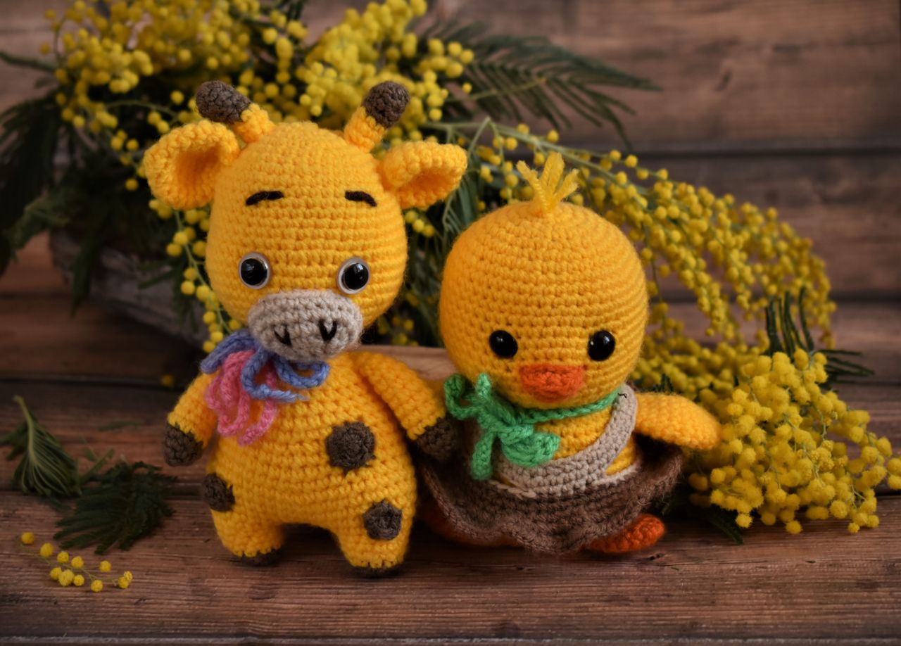 services-04 Charming amigurumi giraffe and chick with vibrant yellow flowers creating a cozy scene.