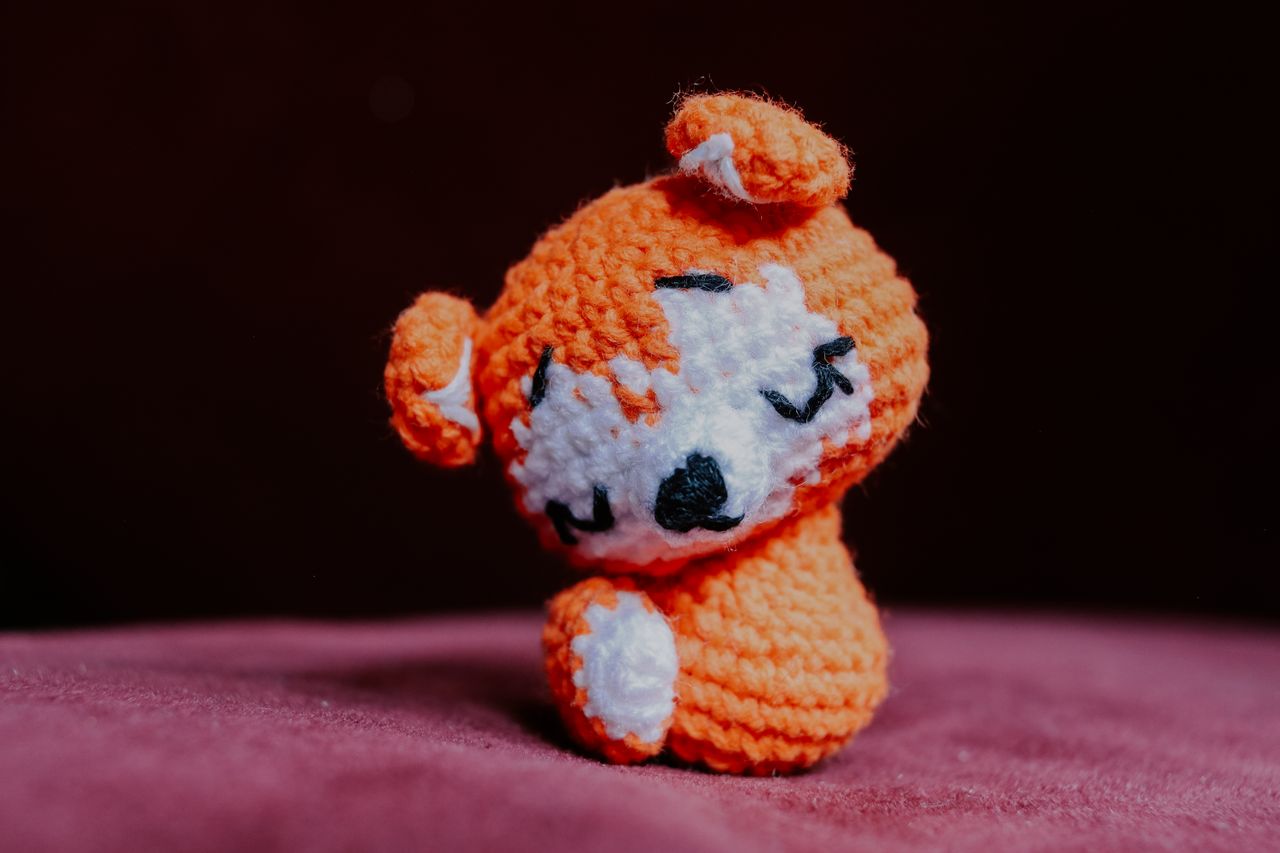 services-03 Adorable handmade orange crochet animal figure on a soft pink surface, perfect for cute and cozy decor.