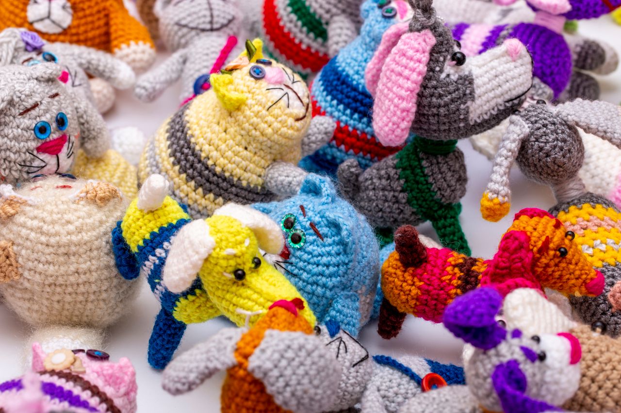 services-02 A collection of vibrant handmade crochet animals in various colors and patterns, showcasing diverse designs.